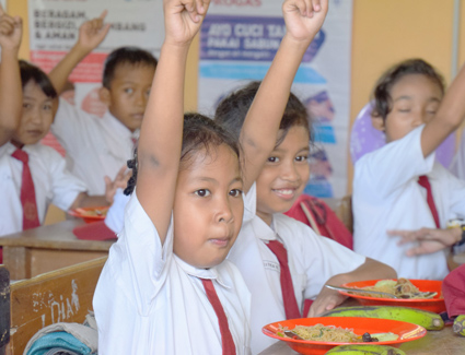 kids raising hands in school