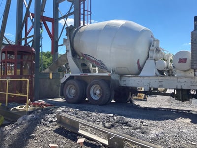 Cement truck filling the concrete bucket for a liner pour. Cement truck filling the concrete bucket for a liner pour.