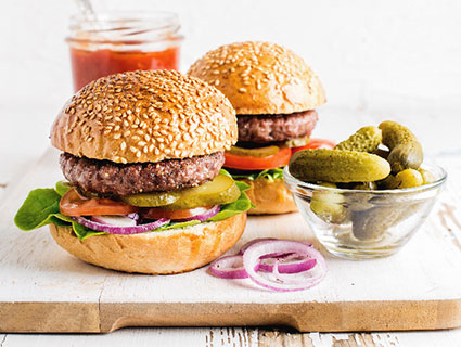Two Burgers On A Wood Plate Two Burgers On A Wood Plate