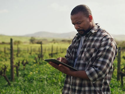 Man Working on a Field with a Tablet