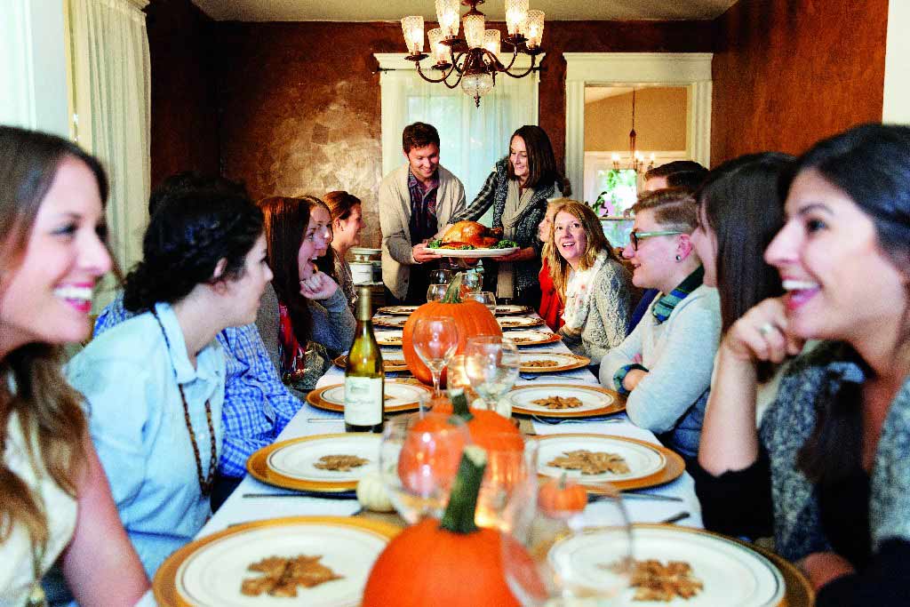 Thanksgiving table with people around it image