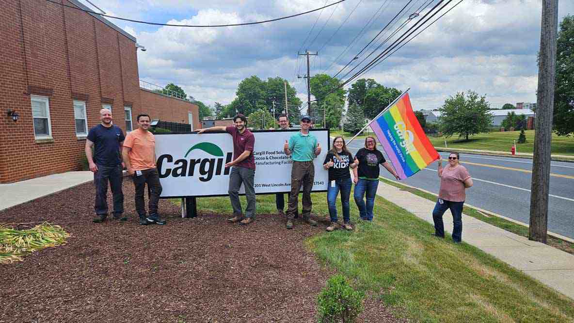 Cargill employees holding a pride flag outside.