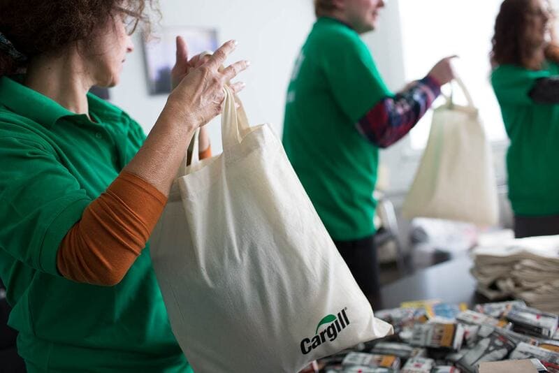 Cargill tote bag being filled with goods for donation image Cargill tote bag being filled with goods for donation image