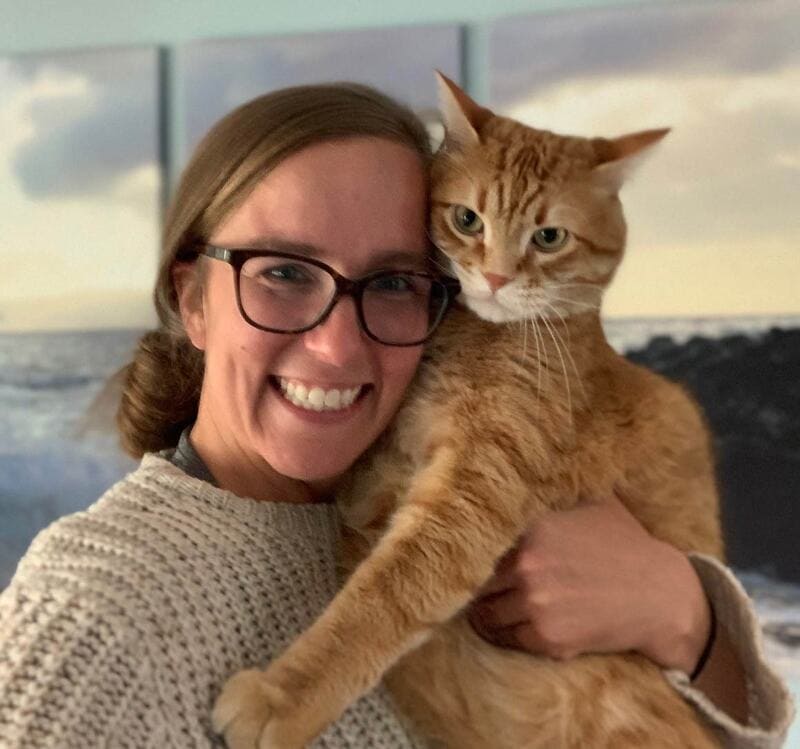 Liz Lindskoog smiling at the camera hodling a cat
