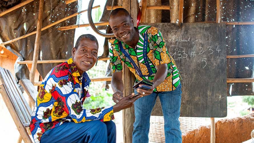 two cocoa farmers holding mobile phones