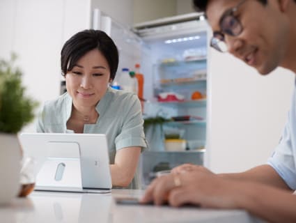 a woman and a man sitting at kitchen table a woman and a man sitting at kitchen table