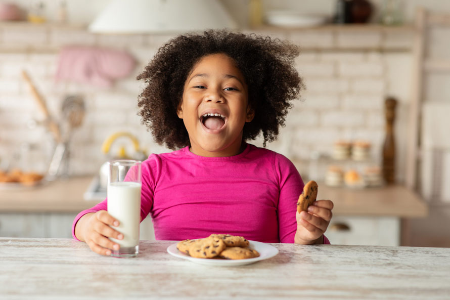 kid with cookie and milk glass