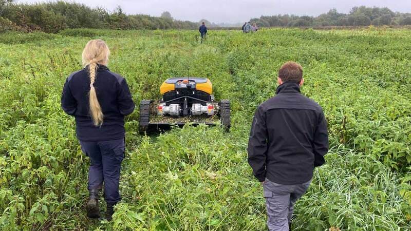 people operating a machine in a field image