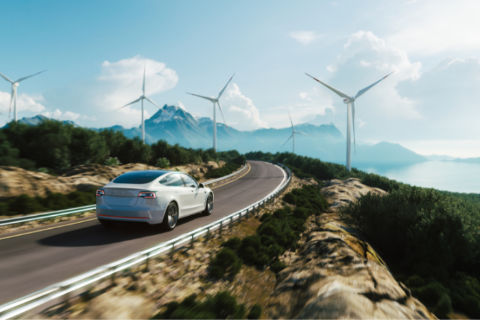 Car driving past wind turbines