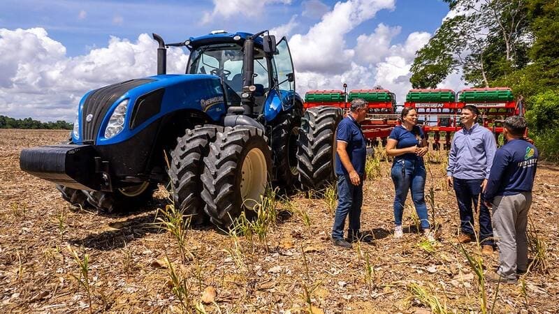 Farmers conversing in field with tractor image