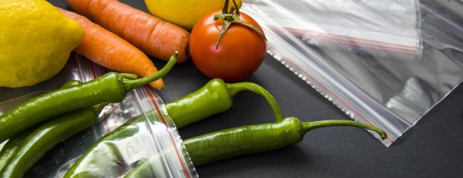 Clear plastic baggies with peppers, carrots, lemons, tomato
