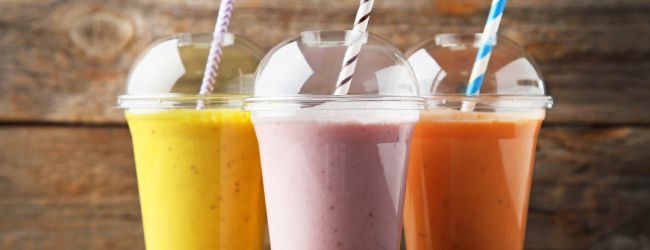 Fruit smoothies in plastic cups with straws