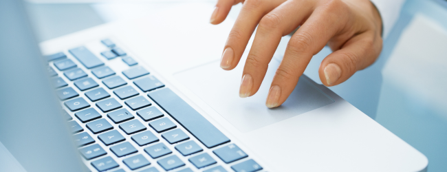 Hand typing on laptop keyboard