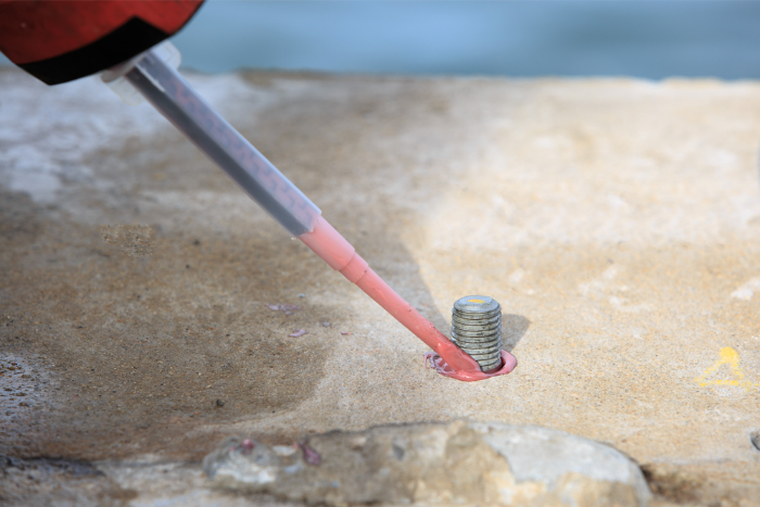 Injecting adhesive material in hole