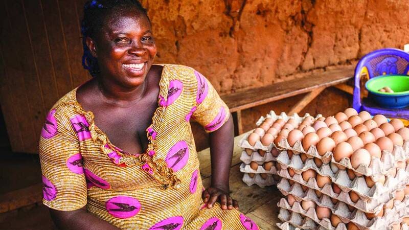 Woman posing next to dozens of eggs.