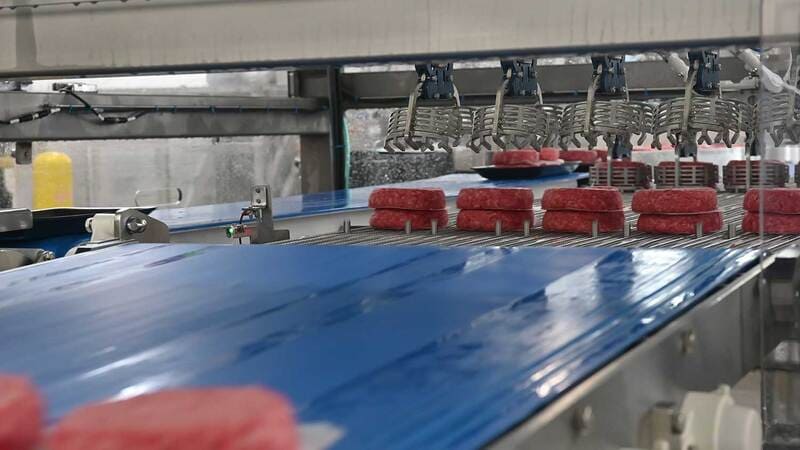 A machine stacks beef patties A machine stacks beef patties