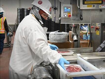 A plant employee examines packaged meat. The packaging process is now automated at more and more Cargill facilities.