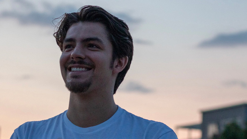 A young man smiling during sunset. 