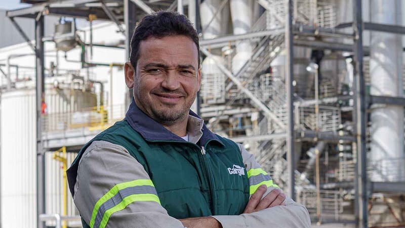 A man smiling at a Cargill facility. 