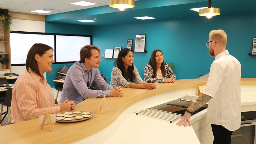 people conversing around a kitchen island image