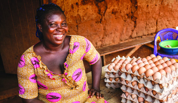 Hatching Hope participant, woman smiling next to packs of eggs image