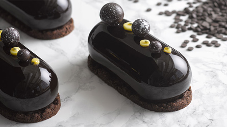 Three chocolate desserts with yellow and black sprinkles.