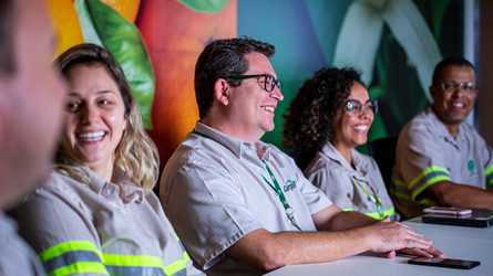 A group of people sitting at a table, smiling and enjoying each other's company.