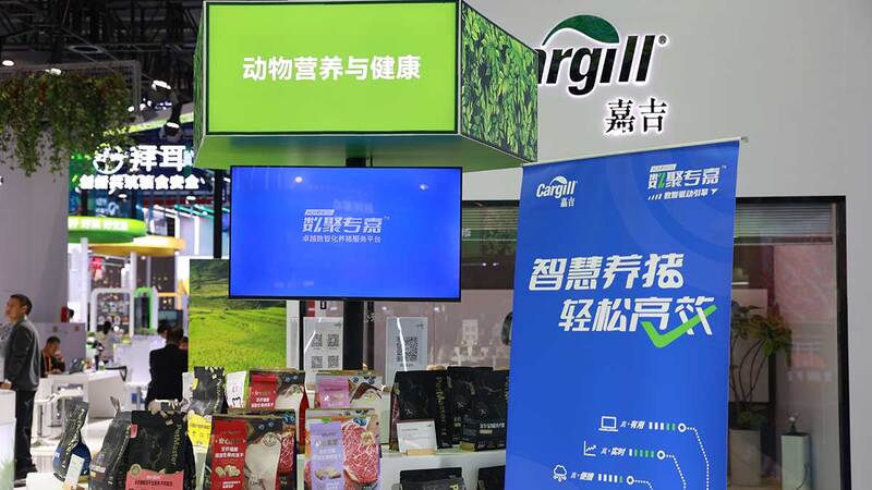 A booth at Cargill’s exhibit at the China International Import Expo with products, a display screen and informational banner.