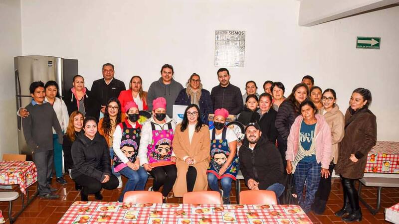 A group of people smile at a community diner in Mexico. A group of people smile at a community diner in Mexico.