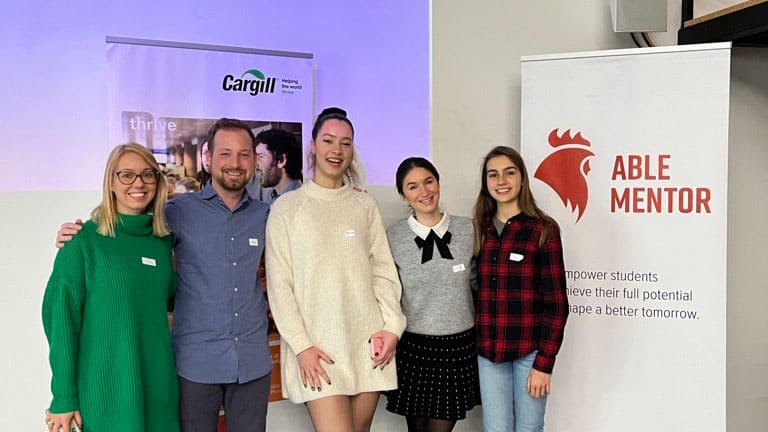 Five colleagues smile during a mentorship event in Bulgaria. Five colleagues smile during a mentorship event in Bulgaria.