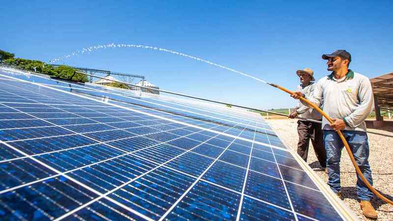 Two men clean solar panels. Two men clean solar panels.