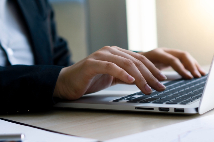 Person typing on laptop keyboard