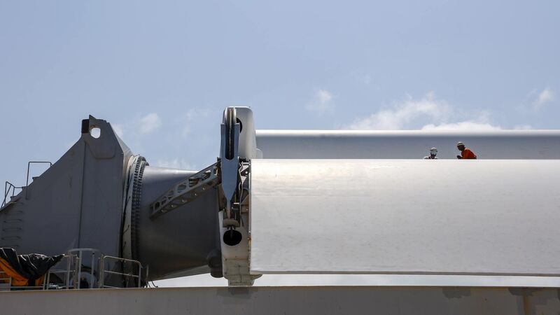 Two crew members working on one of the folded sails of the Pyxis Ocean. Two crew members working on one of the folded sails of the Pyxis Ocean.