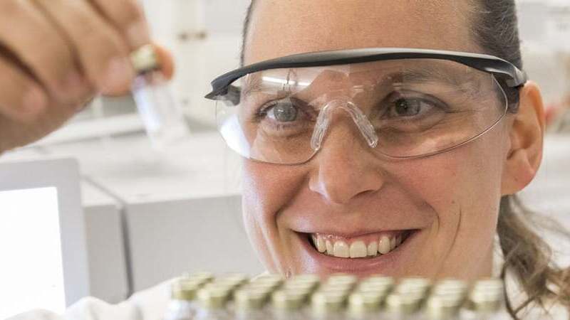 A woman in an innovation lab is examining a vial.