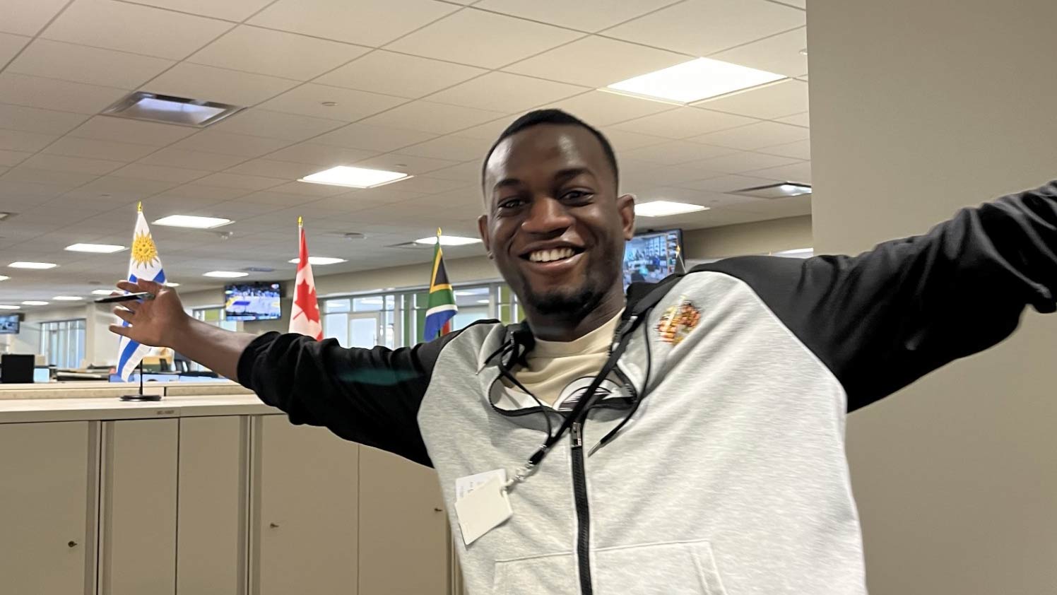 A young man smiles and poses in an office. A young man smiles and poses in an office.