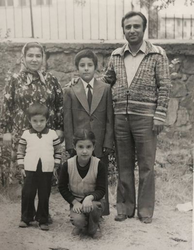 An old picture of three children and their parents posing for the camera.