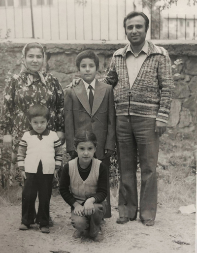 An old picture of three children and their parents posing for the camera. An old picture of three children and their parents posing for the camera.