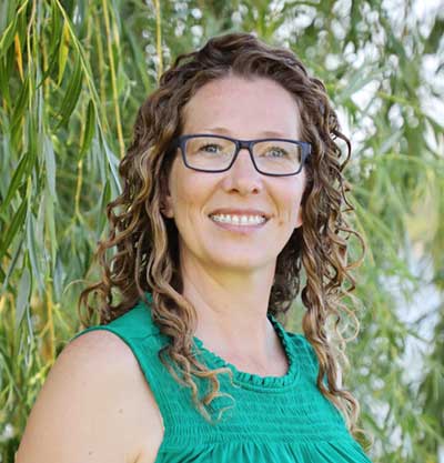  conservation agronomist stands in front of rows of corn.