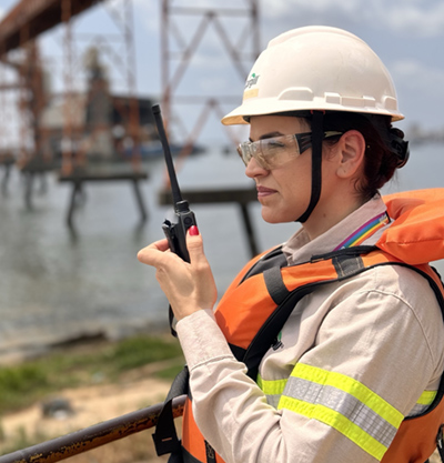  woman stands at a port with a walkie talkie.