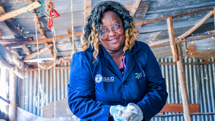 Elizabeth Ndwiga, a poultry producer from Machakos County, Kenya, stands in her coop holding one of her chickens. Elizabeth Ndwiga, a poultry producer from Machakos County, Kenya, stands in her coop holding one of her chickens.