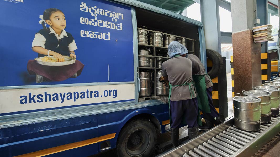 Two men sorting food for the schools’ program in India.