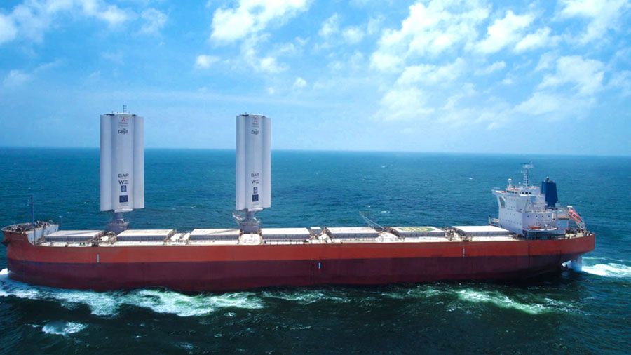 A large ship moves through the ocean with two large sails above it. A large ship moves through the ocean with two large sails above it.