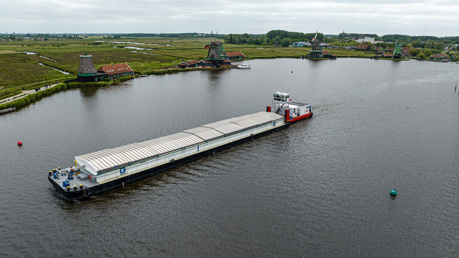 A large ship moves through the waters of a river in The Netherlands. 