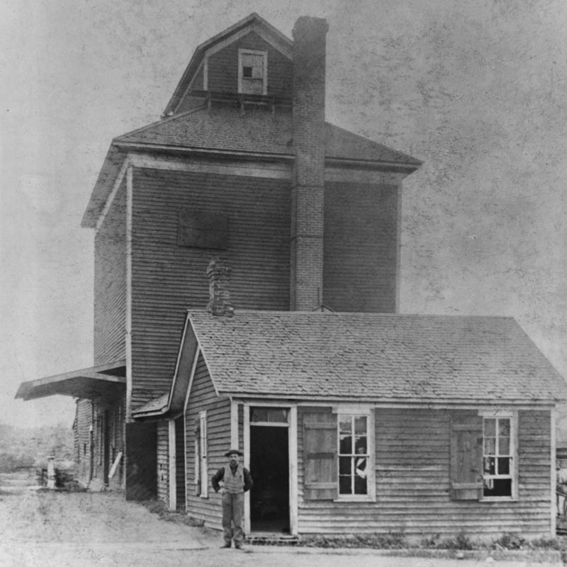 W.W. Cargill stands in front of a two story grain elevator. W.W. Cargill stands in front of a two story grain elevator.