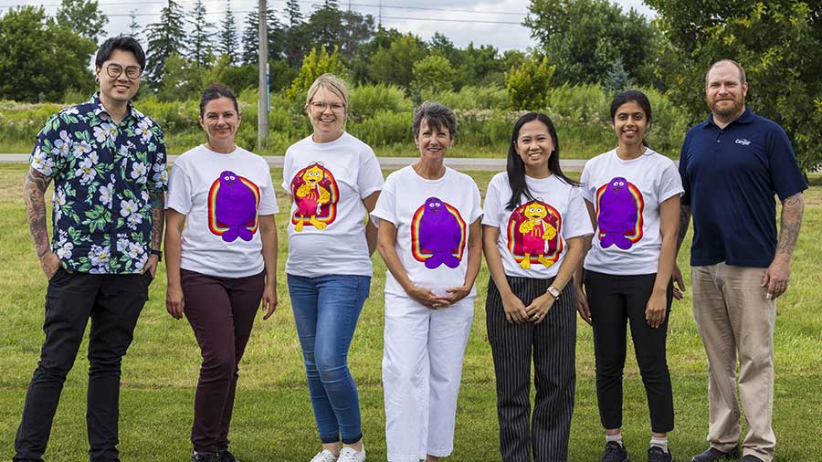 Several Cargill and McDonald’s employees stand in a field of grass and smile. Several Cargill and McDonald’s employees stand in a field of grass and smile.