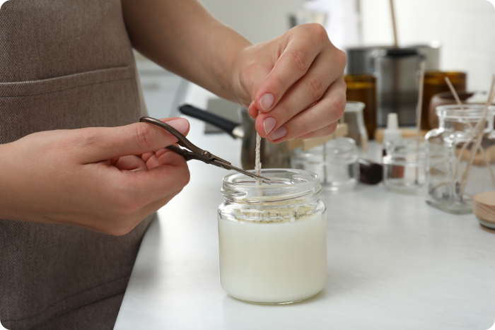 woman clipping wick on homemade candle woman clipping wick on homemade candle