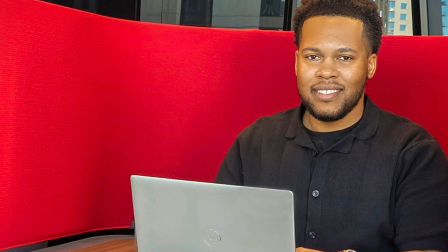 A Cargill data engineer sits in a booth typing on his laptop. A Cargill data engineer sits in a booth typing on his laptop.