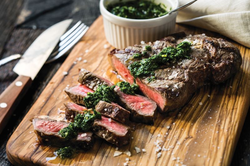 A perfectly seared steak plated on a cutting board.