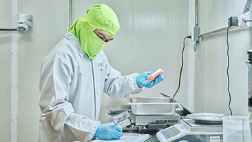 A group of people stand and smile inside a GoldChickenGold restaurant. 