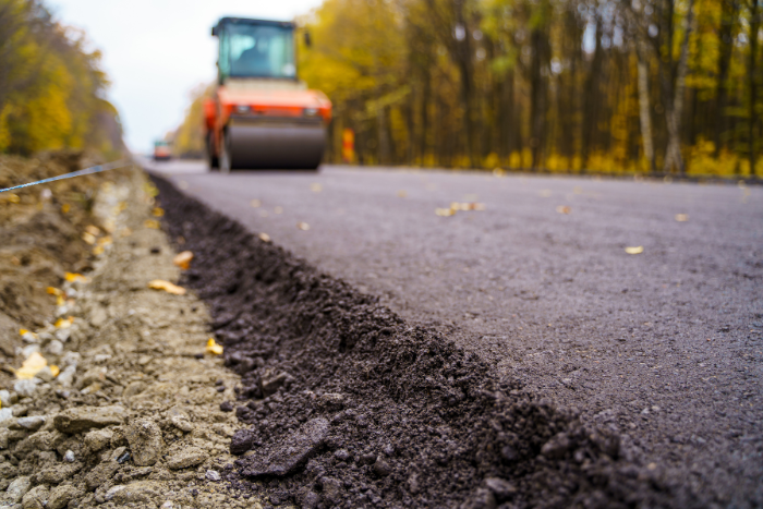 Road repair, compactor lays asphalt
